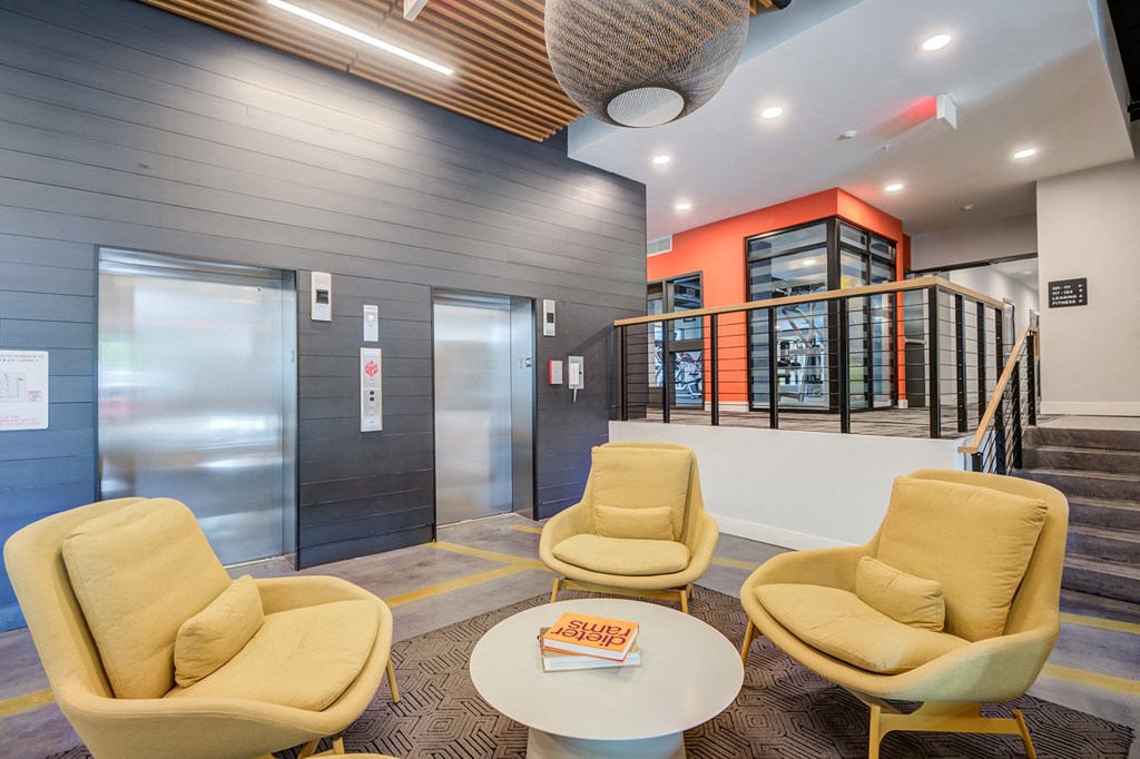 a seating area with yellow chairs and a white coffee table  at Vesta Parkside, Washington, DC