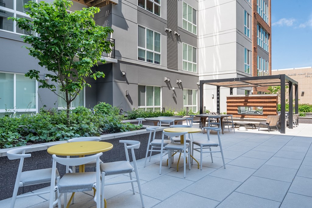 a patio with tables and chairs at the bradley braddock road station apartments  at Vesta Parkside, Washington, DC