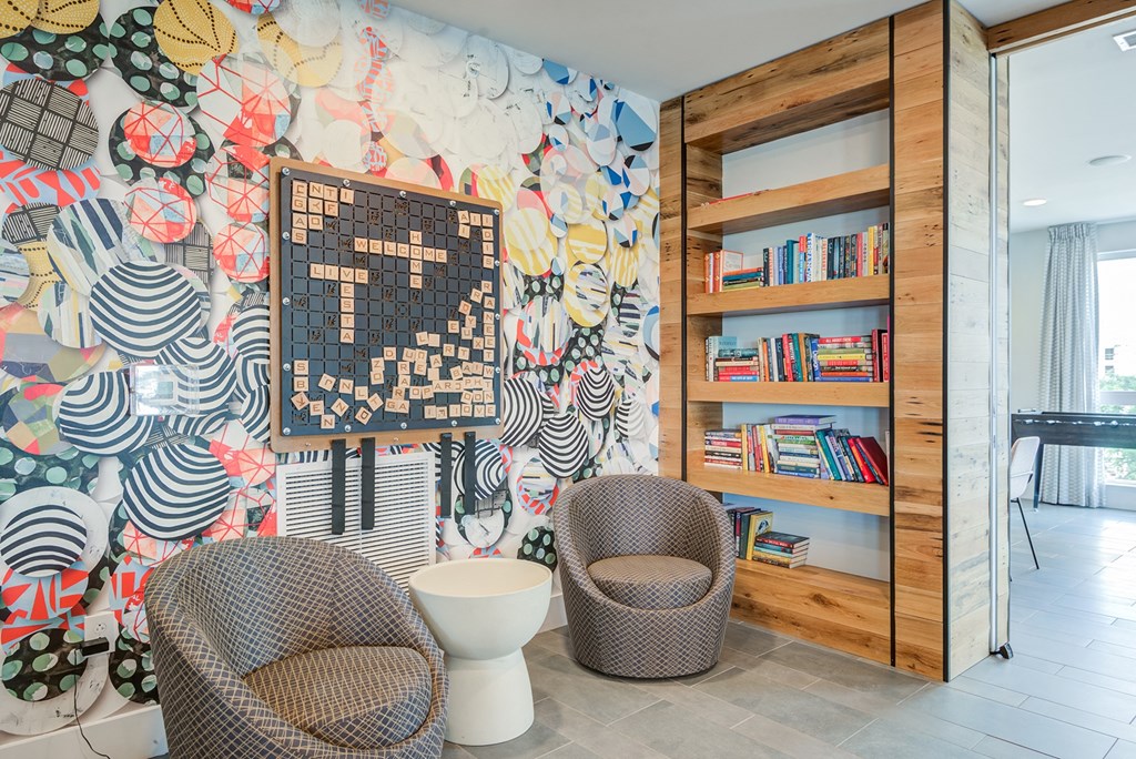 a room with a bookcase and two chairs