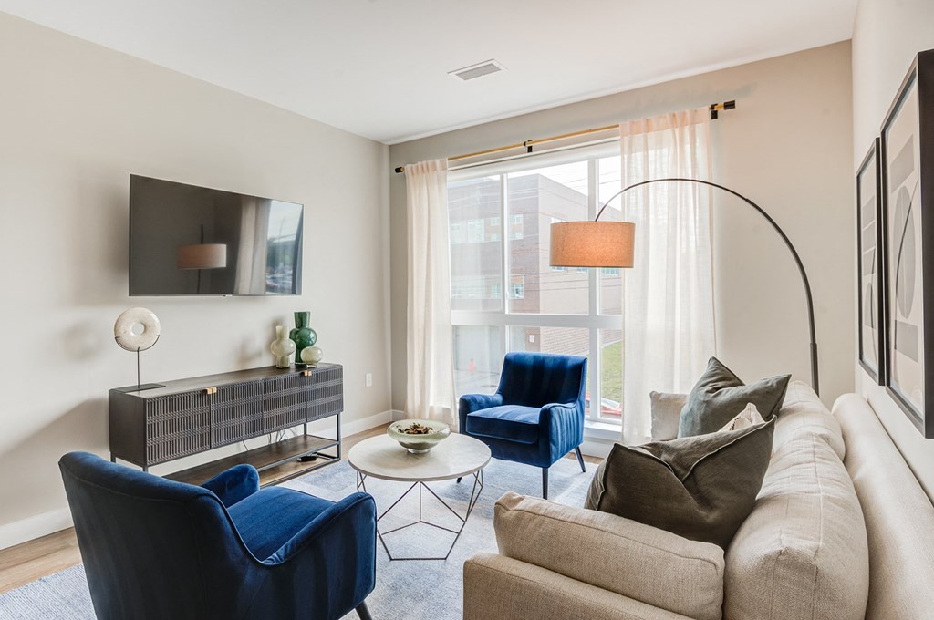 a living room with blue chairs and a couchat Vesta Parkside, Washington, DC