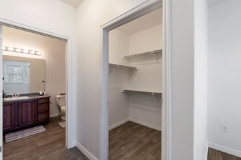 A white wall with a doorway leading to a room with a wooden floor.