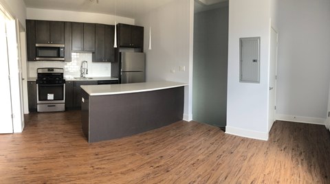 A kitchen with dark wood cabinets and a white island.