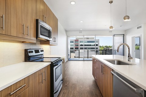 a large kitchen with wooden cabinets and a sink