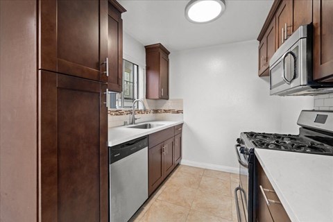 A kitchen with brown cabinets and a black stove top.