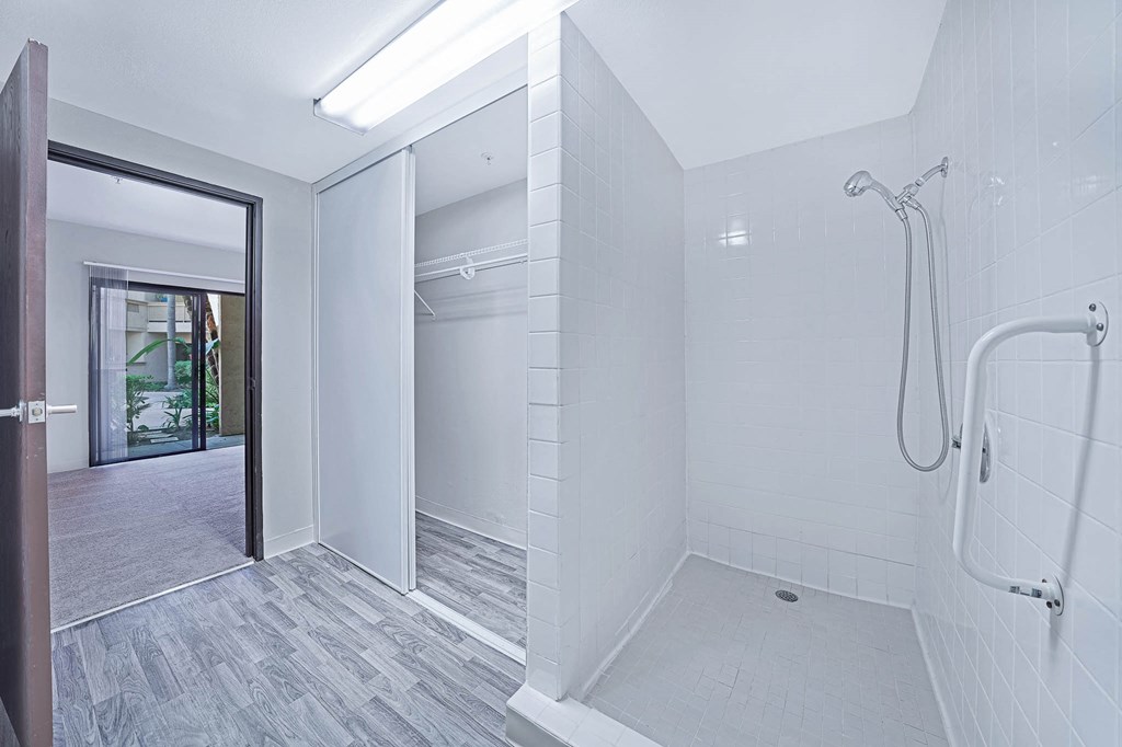 a white bathroom with a shower and a sliding glass door
