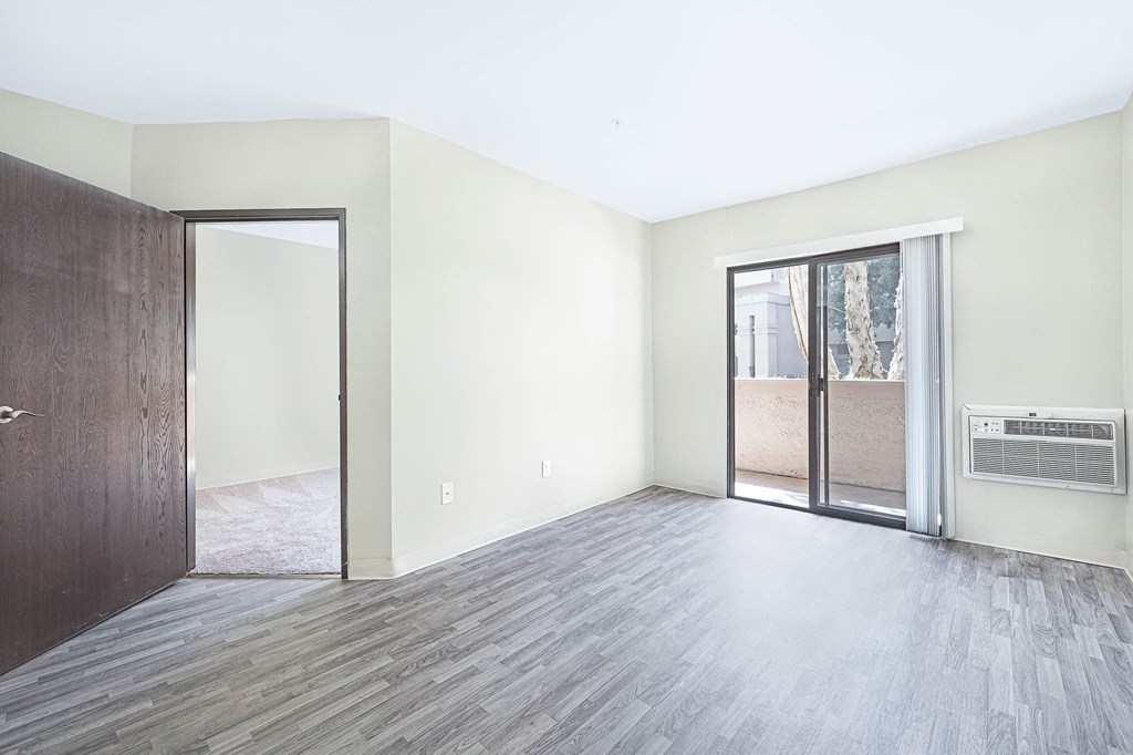 an empty living room with a sliding glass door to a patio