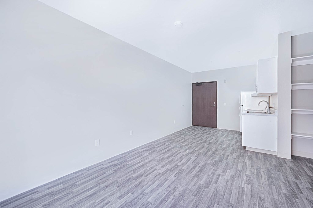 an empty room with a refrigerator and a sink