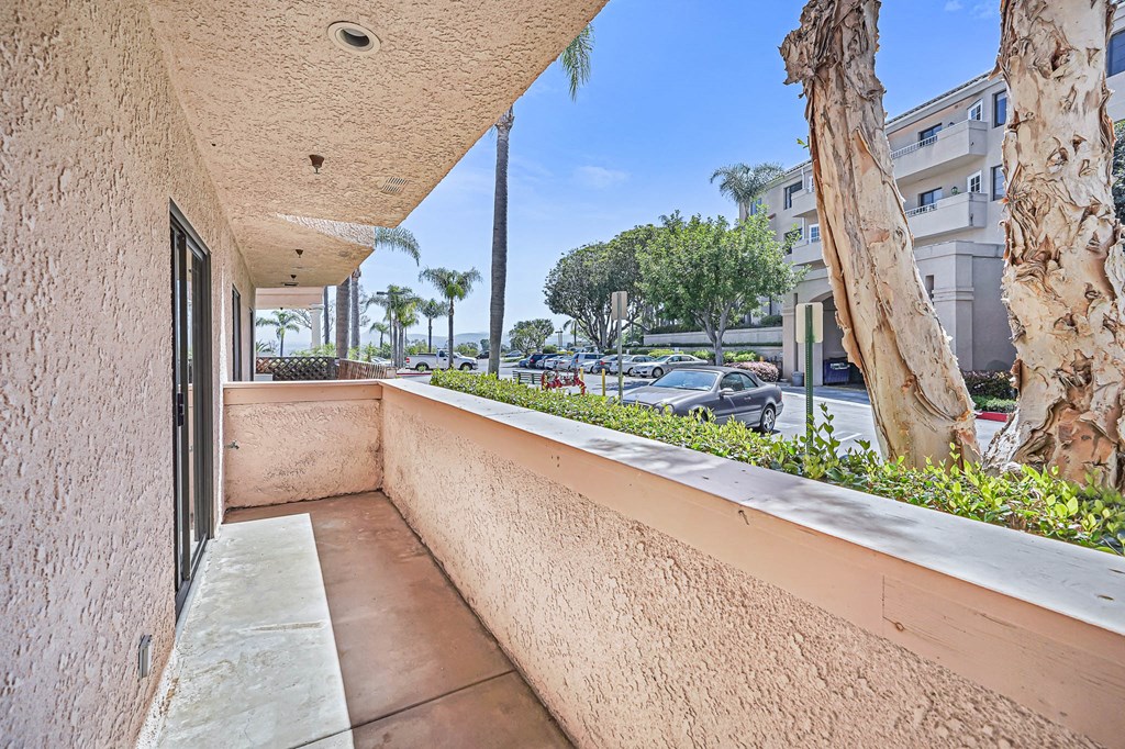 a balcony with a view of the street and palm trees