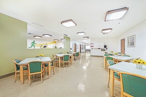 a dining room with tables and chairs and a kitchen