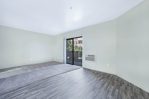 a living room with white walls and a door to a patio