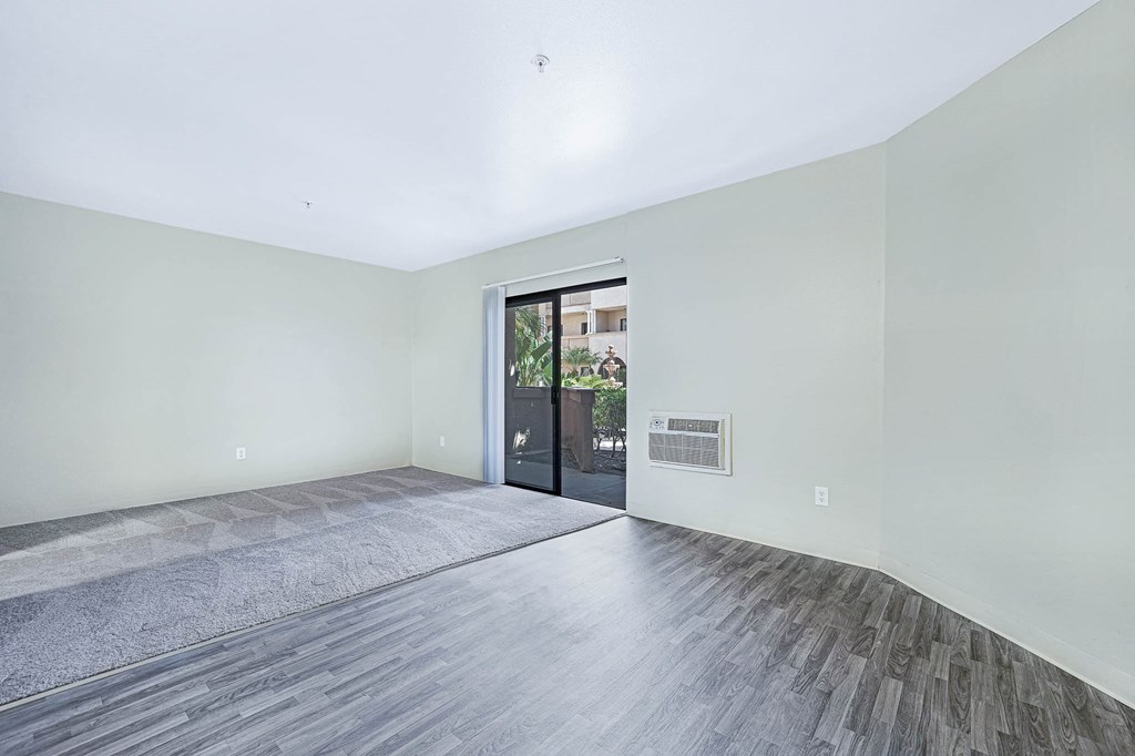 a living room with white walls and a door to a patio