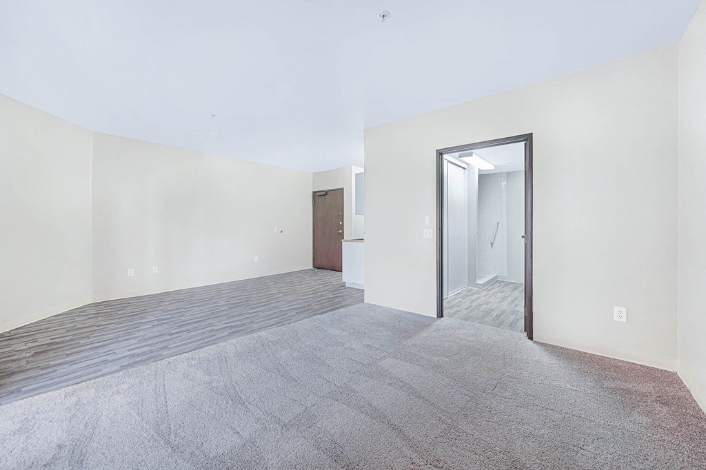 a empty living room with a door to a hallway