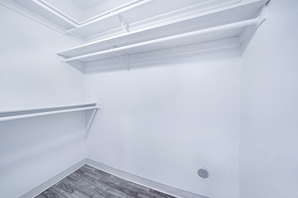 an empty room with white walls and a white walled closet with a fluorescent light