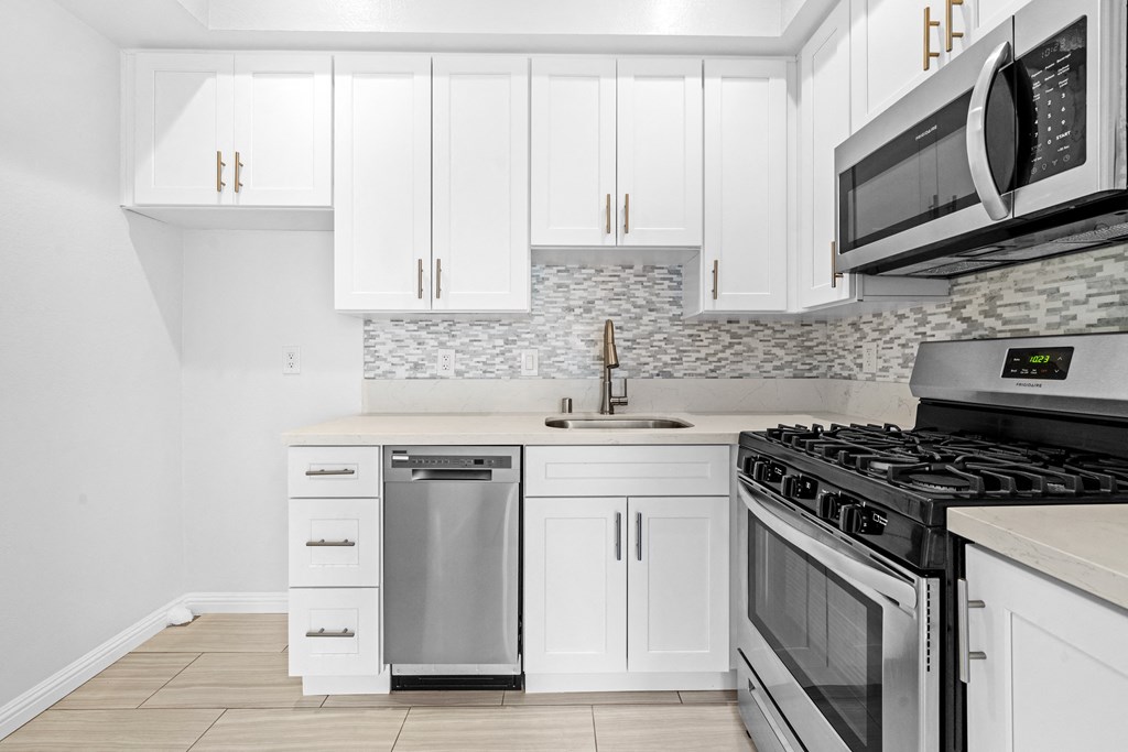 White Kitchen with Stainless Steel Appliances a white kitchen with stainless steel appliances and white cabinets at Hollywood Vista in Los Angeles, CA