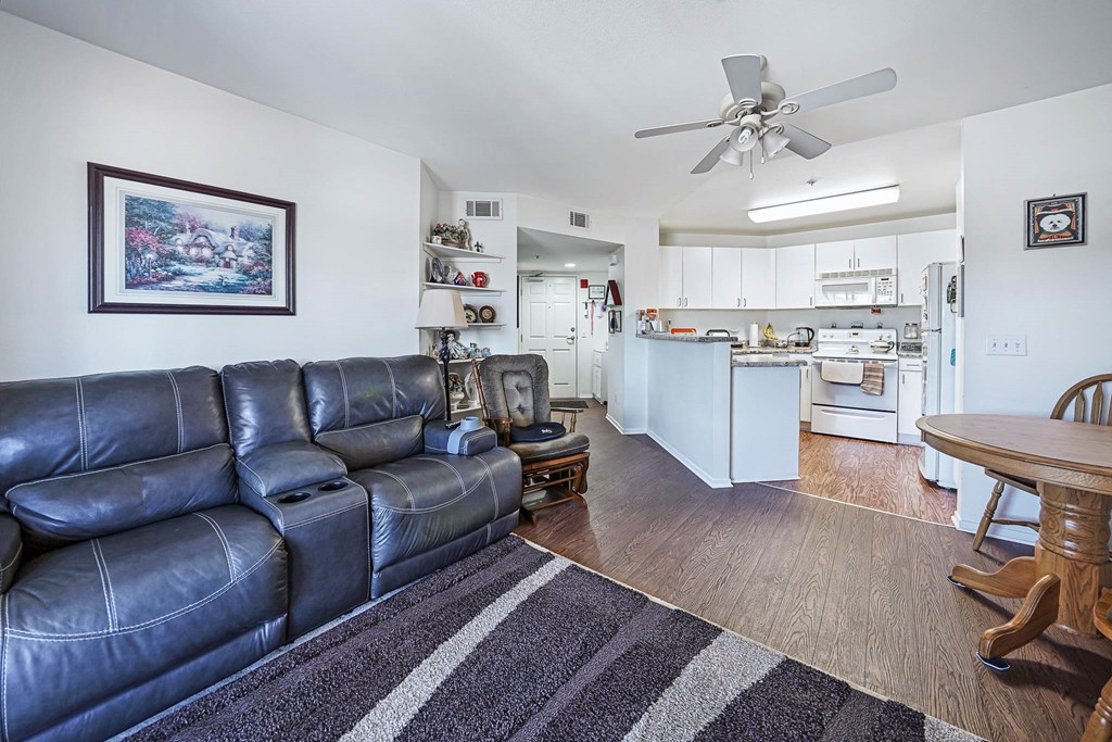 a living room with leather furniture and a kitchen with a table