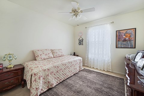 a bedroom with a bed and a ceiling fan