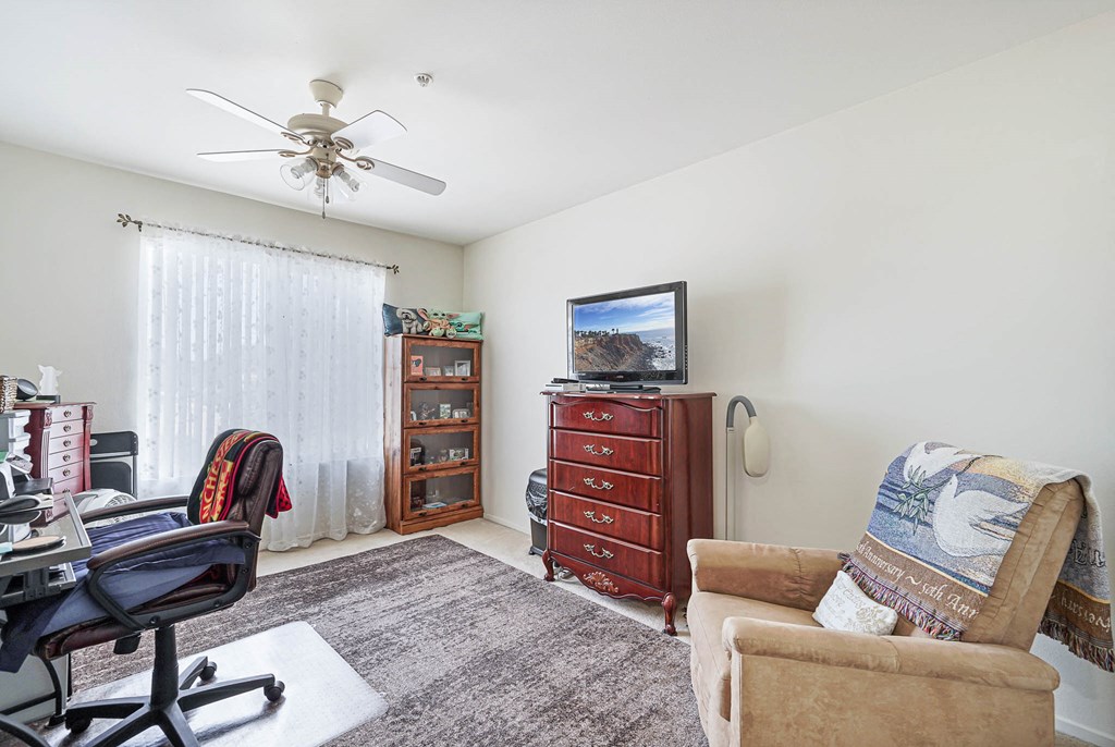 a living room with furniture and a ceiling fan