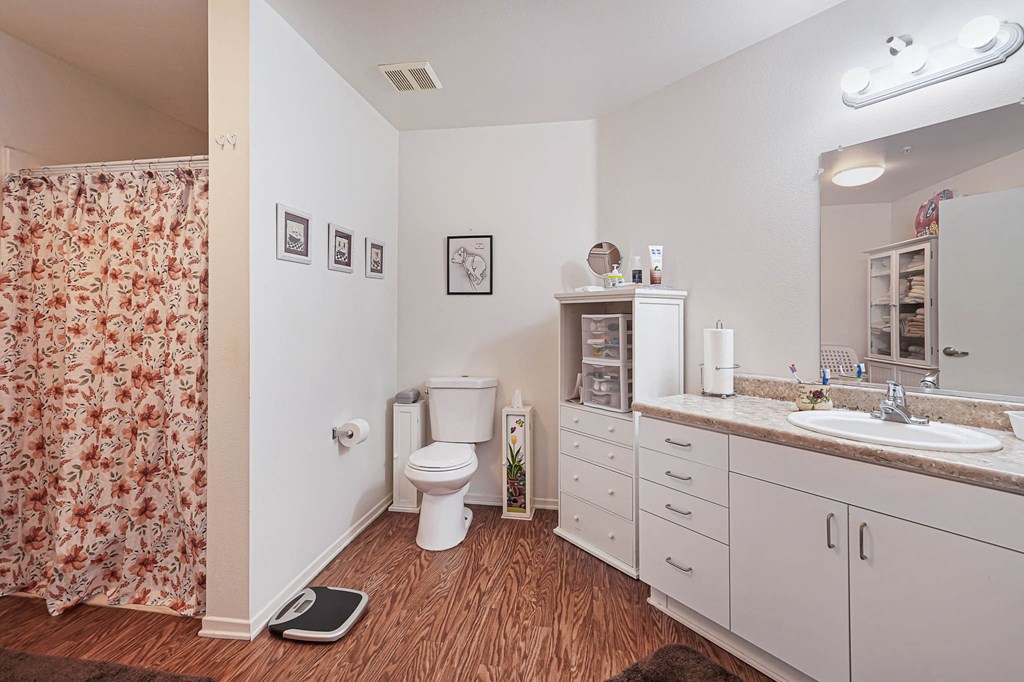 a bathroom with a toilet sink and shower and a mirror