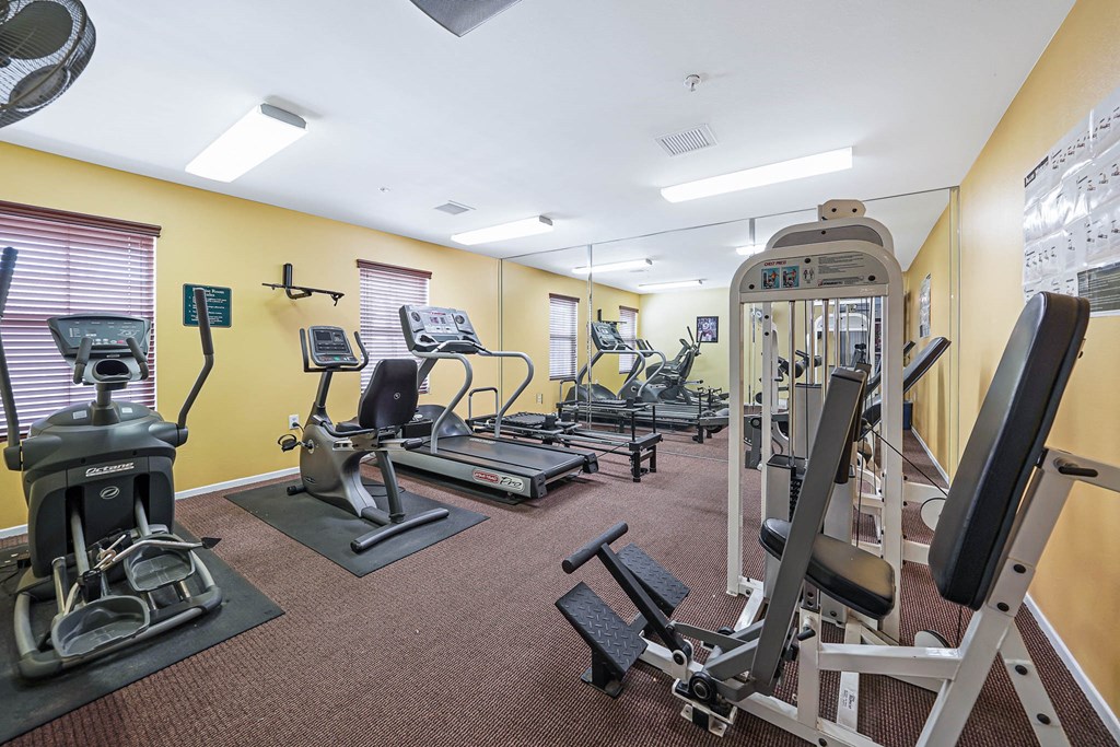 a gym with various machines and weights on the floor