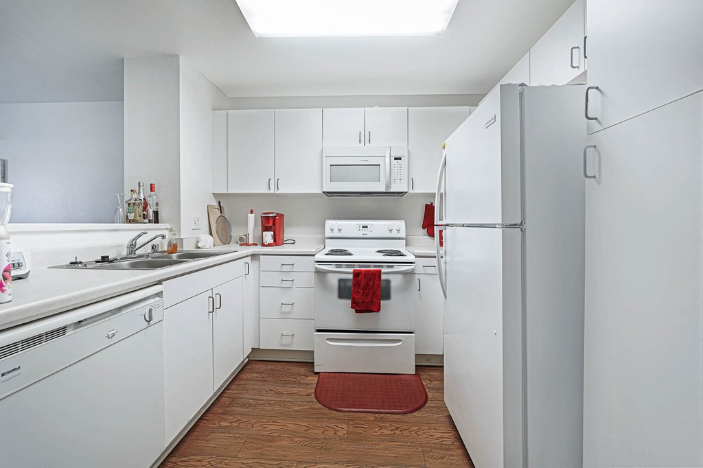 a white kitchen with white appliances and white cabinets