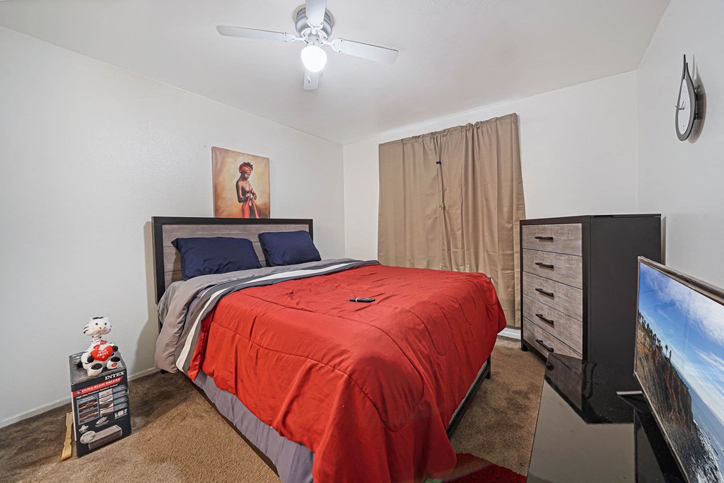 a bedroom with a bed and a ceiling fan