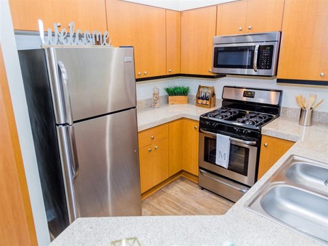 a kitchen with stainless steel appliances and wooden cabinets