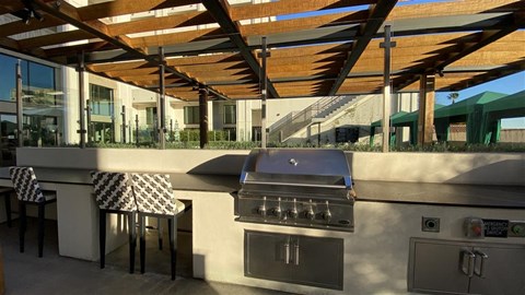 an outdoor kitchen with a grill and a table
