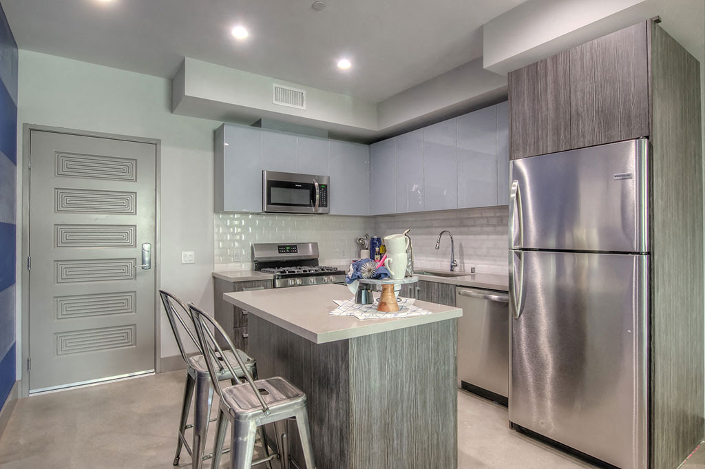 Kitchen With Island And Bar Seating And Stainless Steel Appliances At The Mansfield at The Mansfield at Miracle Mile, Los Angeles, CA , 90036