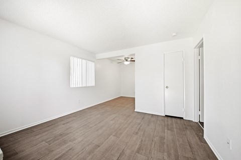 A room with a wooden floor and white walls. at Heritage Park, Rialto, CA