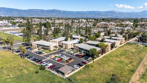 A parking lot in front of a building with a mountain in the background. at Heritage Park, Rialto, CA 92376