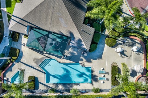 An aerial view of a house with a pool and a patio area. at Whispering Fountains Lakewood, Lakewood Bar, CA
