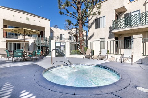 A small pool with a fountain in the middle of a courtyard.