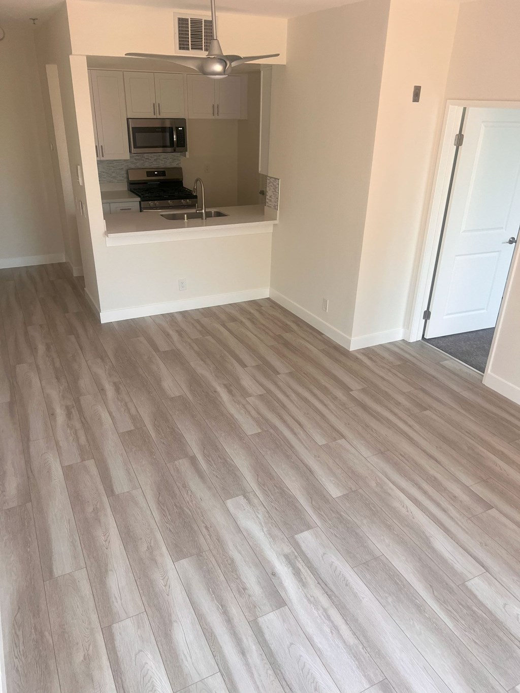 A kitchen with a microwave, oven, and refrigerator.