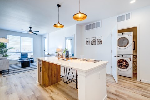 Kitchen Island and stacked washer & dryer at Tempo Nine Mile Station in Aurora, Colorado