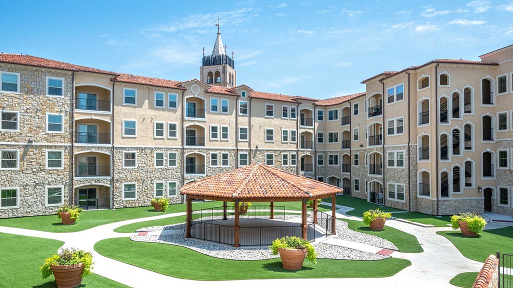 Your Best Years Are Here The cabana in the courtyard of Bell Tower Reserve, the apartment building surrounding it behind on a sunny day.