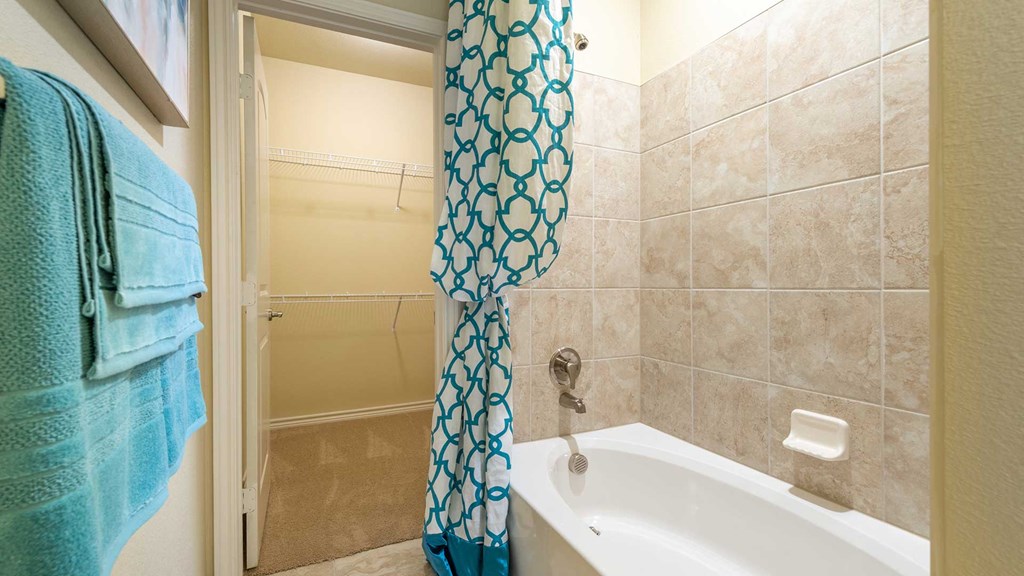 Looking into a bathroom in a residence at Bell Tower Residence, the tub on the right and linen closet ahead on the left.