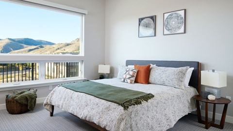 Epoque Golden apartment bedroom with large windows, modern furnishings and expansive foothill views.