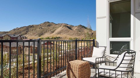 Epoque Golden apartment balcony with outdoor seating and expansive foothill views.