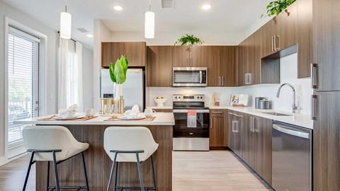 A modern kitchen with a dining table set for two.