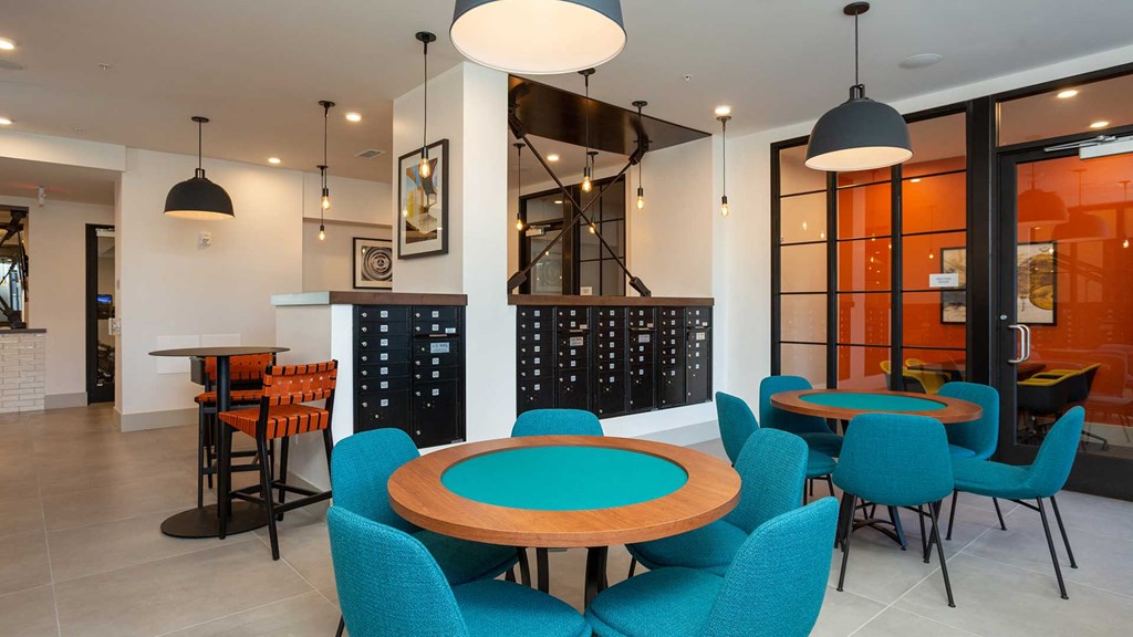 Two game tables sit side-by-side with a private workspace off to the right. There are mailboxes built-in behind the tables.