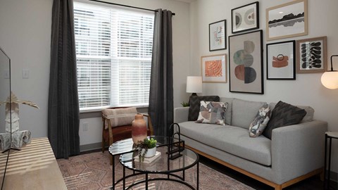 a living room with a couch and a coffee table    and a window