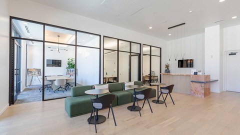 Modern coworking lounge and private meeting rooms with contemporary seating and workspace design at Tempo at Nine Mile apartments.