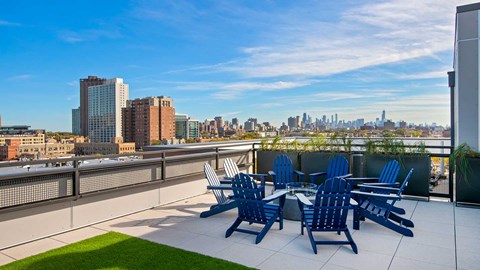 Standing before the fire pit are on the rooftop deck at Wrigleyville Lofts with the Chicago skyline seen in the distance.