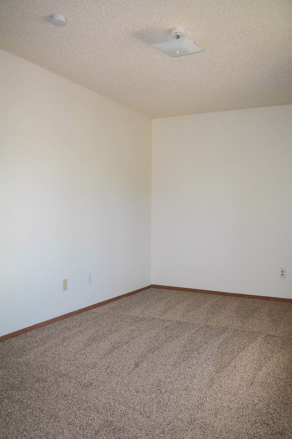 an empty room with carpet and white walls