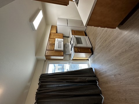 A view of a staircase leading to a kitchen area with a window.