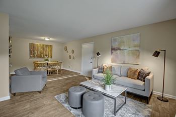 A living room with a grey couch, a coffee table, and a painting on the wall.