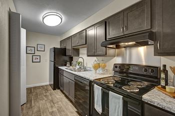 A modern kitchen with dark wood cabinets and stainless steel appliances.
