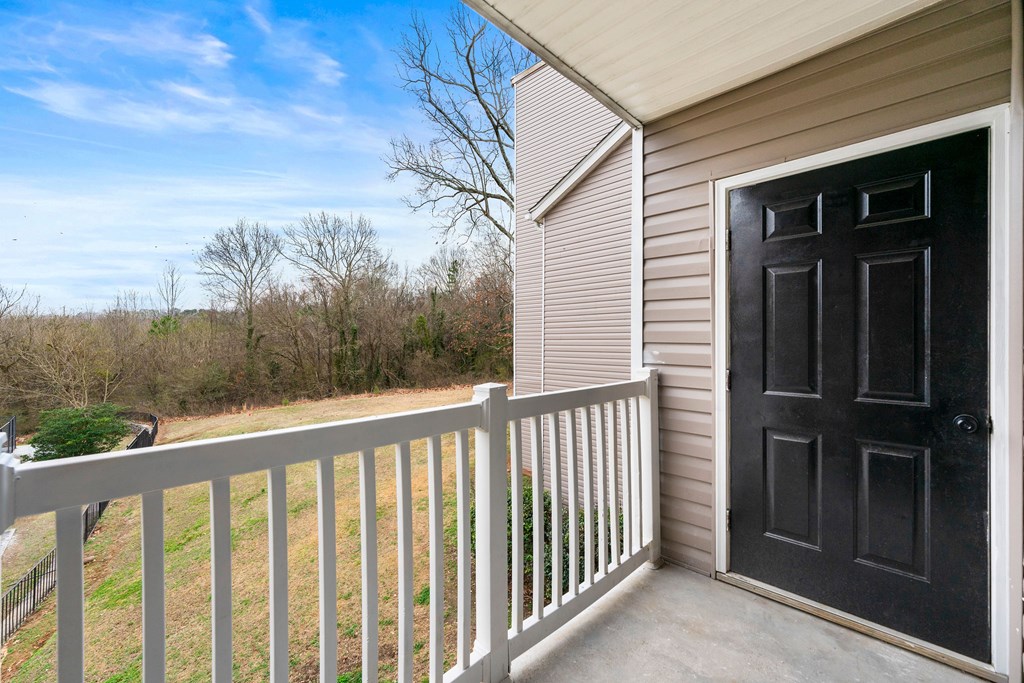 A black door is on the right side of a white railing A black door is on the right side of a white railing at 2000 Oasis in Atlanta, GA 30316