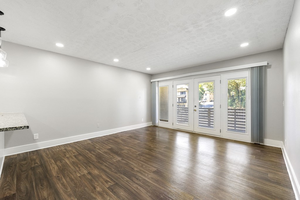 Living room with updated flooring and private patio at Balfour Chastain, Sandy Springs, GA