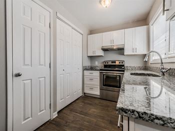 a kitchen with white cabinets and stainless steel appliances at Balfour Chastain, Sandy Springs, GA
